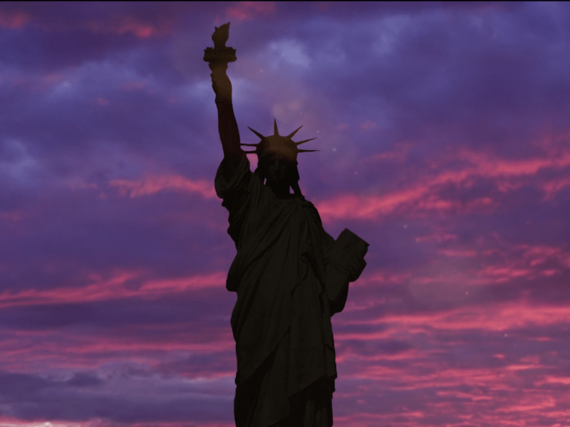 silhoutte of statue of liberty against purple skies