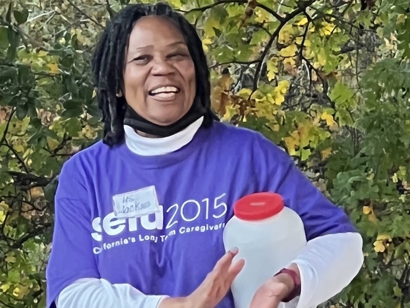 smiling woman in purple shirt faces the camera. Her shirt reads SEIU 2015.
