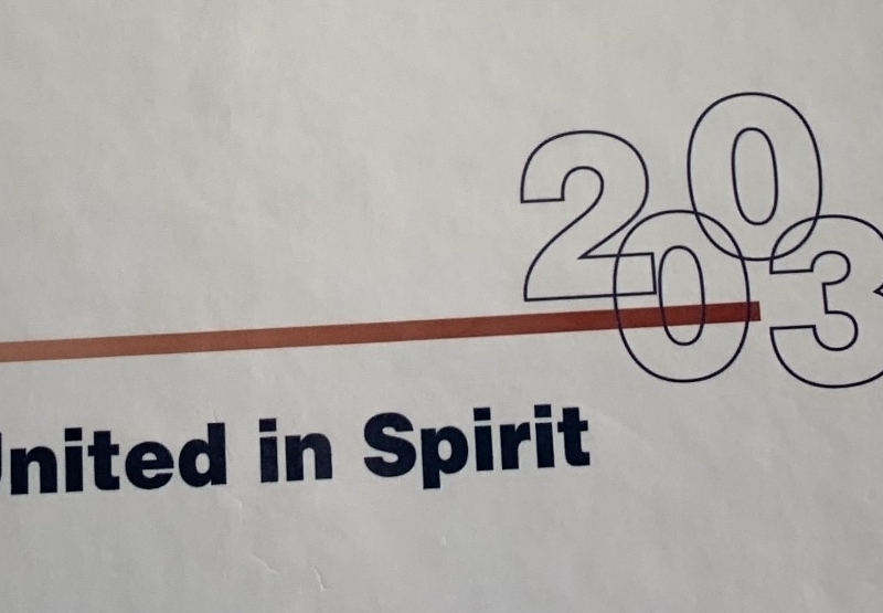 white background with red line and numbers 2003 and words "United in Spirit"